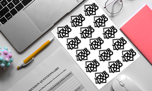 Lugar de trabajo con portátil, bolígrafo, cuaderno y hoja de pegatinas 