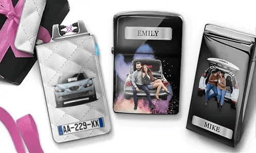 Drei personalisierte Zigarettenetuis sind zu sehen. Das erste zeigt ein Auto mit Kennzeichen. Das zweite zeigt ein Paar, das auf einem Auto sitzt, mit der Aufschrift „Emily“ vor farbenfrohem Hintergrund. Das dritte zeigt ein Paar im Kofferraum eines Autos, mit der Aufschrift „Mike“. Rosafarbene Schleifenakzente sind sichtbar.