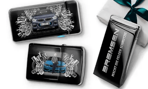 Drei Auto-Themen-Artikel mit Auto-Illustrationen und Maschinen-Motiven, arrangiert neben einer Geschenkbox, die mit einer grünen Schleife gebunden ist.