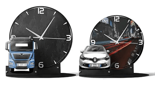 Two decorative clocks with model vehicles: left with black marble face and blue truck, right with cityscape and red sports car