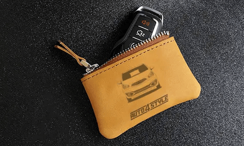 Two brown leather key pouches with zippers: one with motorcycle and plate 