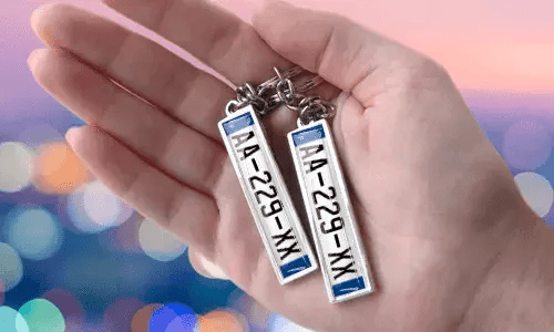 Portachiavi con targa personalizzata e numeri personalizzati, tenuto in mano