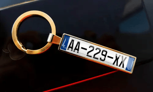 Porte-clés plaque d’immatriculation attaché à des clés dans la poche, avec une voiture en arrière-plan