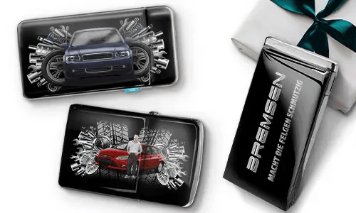 Three sleek black wallets with images of cars and gears, placed near a gift box. 