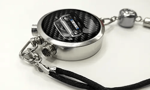 Round car key fob with carbon fiber face, buttons labeled LOCK and UNLOCK, braided black cord attached