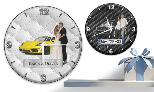 Two wall clocks with formal couple and sports cars: left with yellow car on quilted silver, right with black car on carbon background