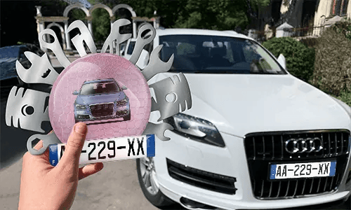 Autoschlüsselanhänger in der Hand mit dem Wagen auf dem Hintergrund individueller schlüsselanhänger